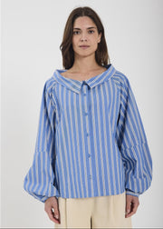 Woman wearing a blue and white striped shirt against a plain background