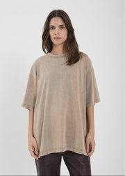 Woman wearing a beige oversized t-shirt on a white background