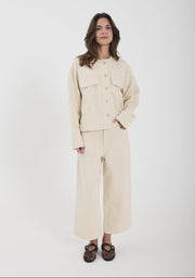 Woman wearing a beige outfit on a white background