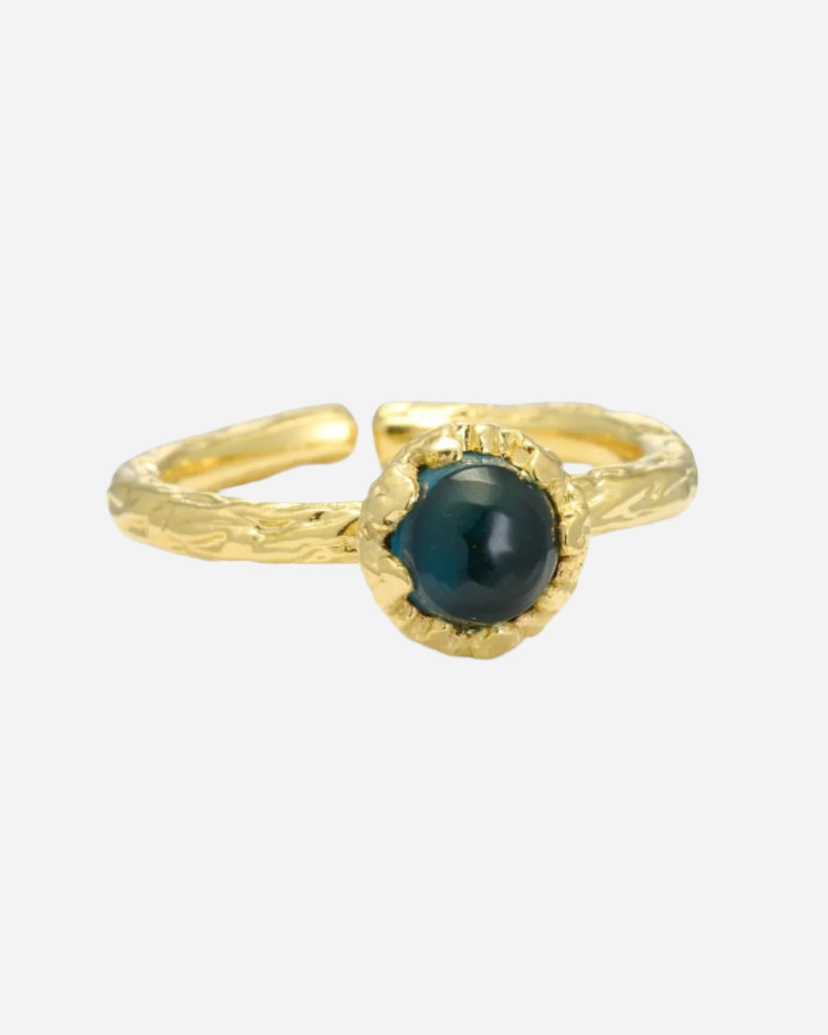 Gold ring with a deep violet, almost black, gemstone on a white background