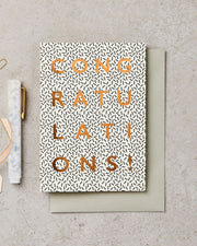 Greeting card with 'Congratulations!' text on a textured surface