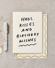 Greeting card with 'Hugs, Kisses and Birthday Wishes' text on a beige background