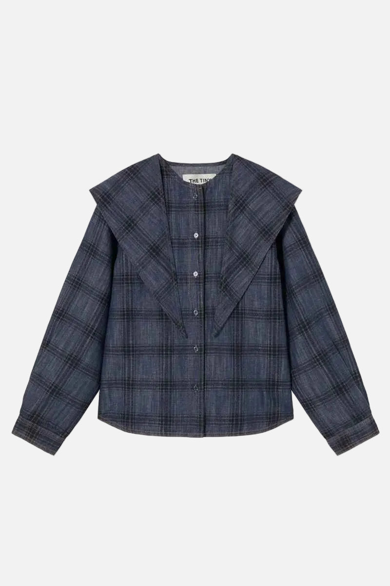 A navy blue plaid button-up shirt jacket with a wide collar, laid flat against a light cream background.