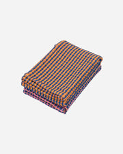 Folded fabric with blue and orange checkered pattern on a white background