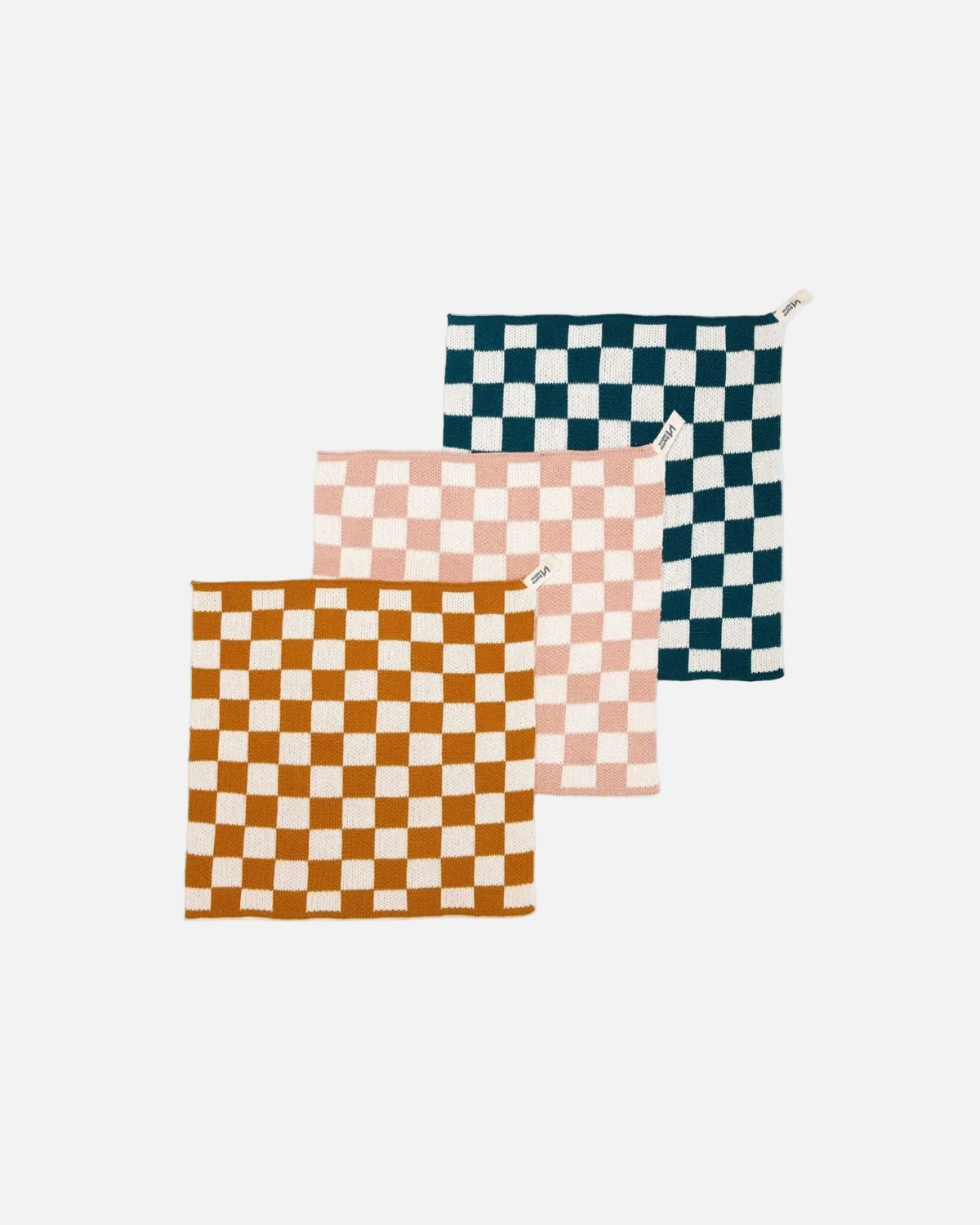 Three square checkered kitchen towels or napkins in orange, pink, and navy blue and white, arranged diagonally on a white background.