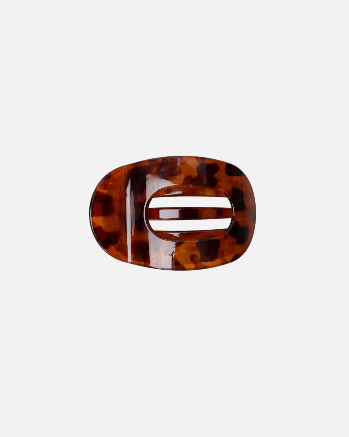 A single oval hair claw clip with a glossy tortoiseshell pattern in shades of brown and amber, shown on a plain white background.