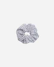 A fabric scrunchie with a light blue and white striped pattern, centered on a solid white background.