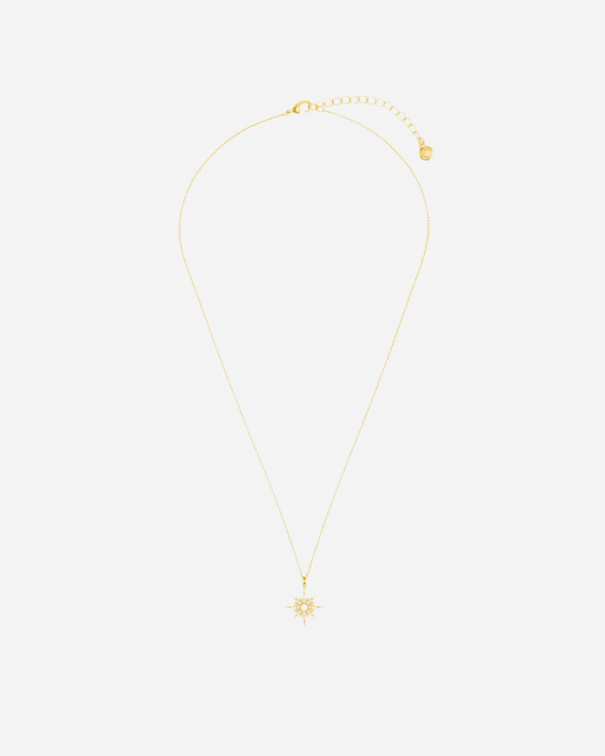 Gold necklace with a small pendant on a white background