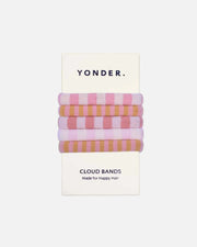 A set of four Yonder Cloud Bands in pastel pink, peach, lavender, and tan stripes, packaged on a white card with the brand name YONDER.
