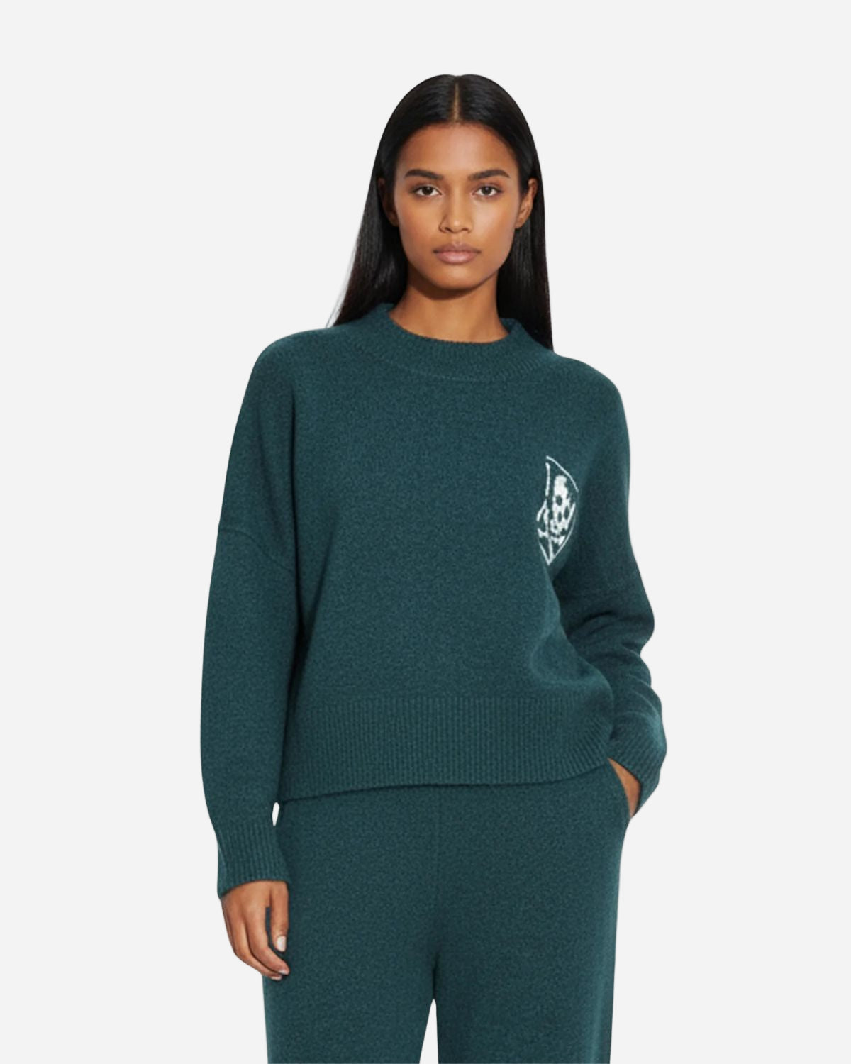 Woman wearing a teal sweater with a logo on a white background