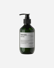 A pump bottle of Meraki body lotion with the label 'LINEN DEW' and text indicating organic ingredients.
