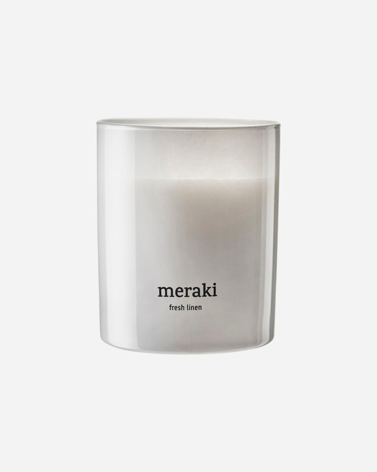 A white, scented candle with the brand 'meraki' written on it, with a clear glass casing.