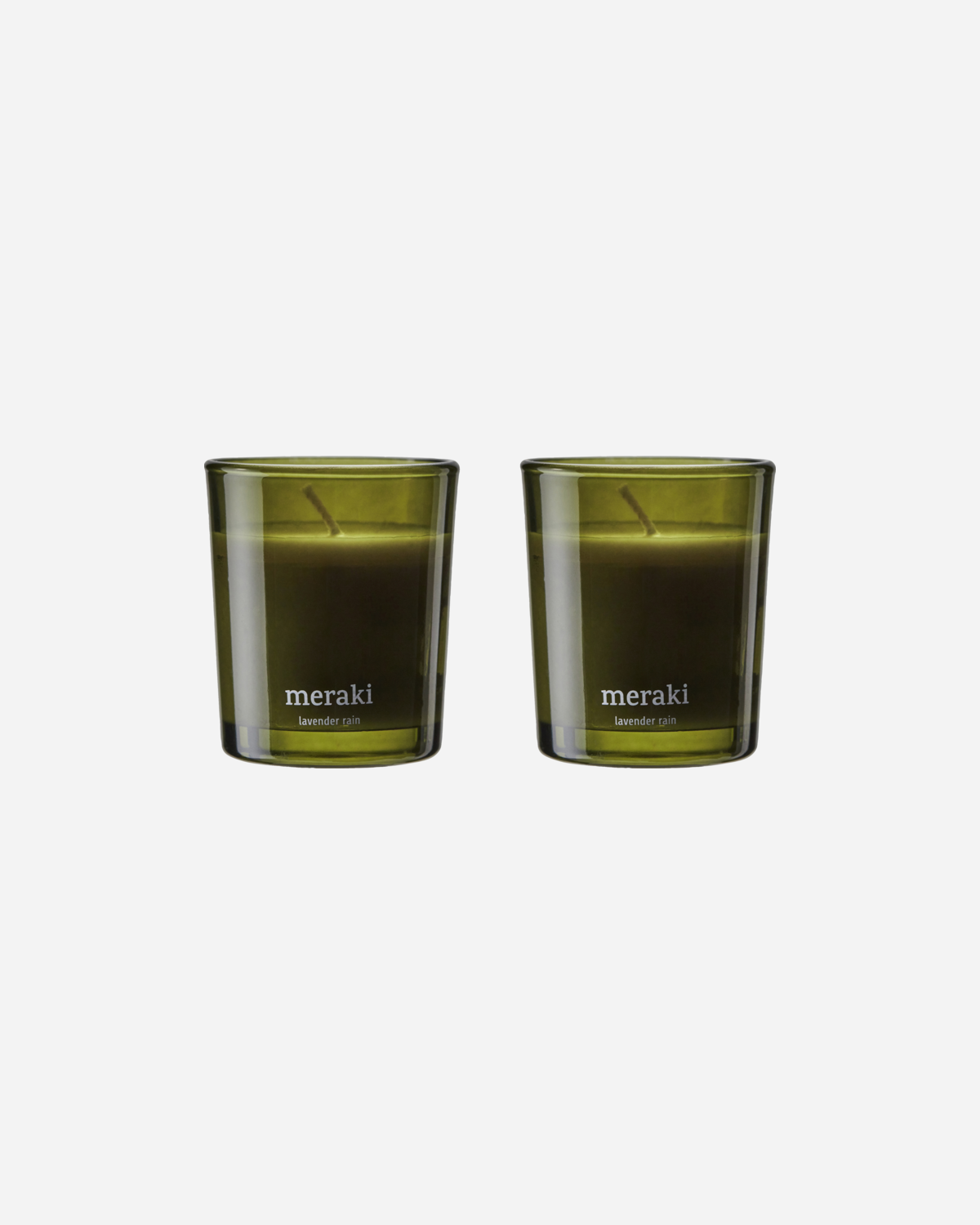 Two green glass candles with the Meraki brand logo, set against a white background.