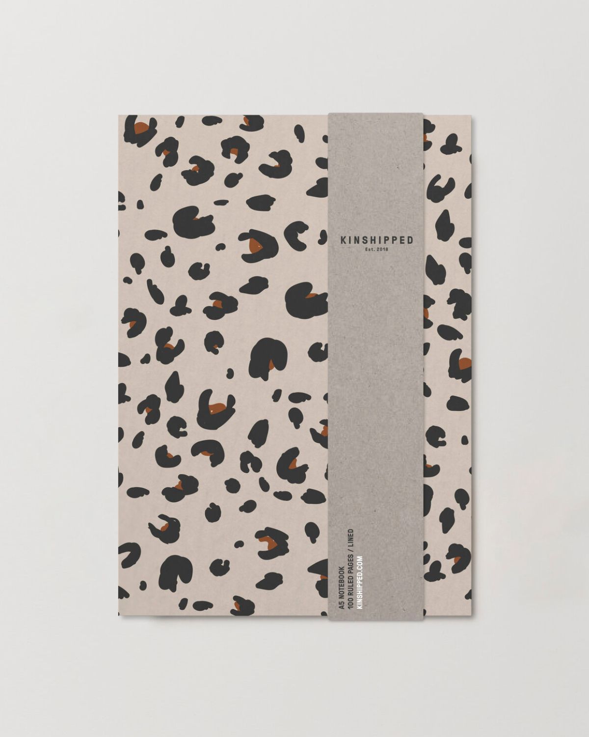 Notebook with leopard print cover and gray spine on a light gray background