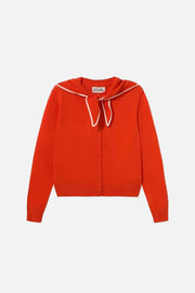 A bright red knit cardigan sweater with a white-trimmed sailor-style collar and a matching bow, shown flat against a light cream background.