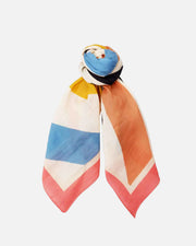 A lightweight square scarf with a colorful geometric pattern, featuring blocks of blue, orange, pink, yellow, and white, styled in a knot at the top on a solid white background.