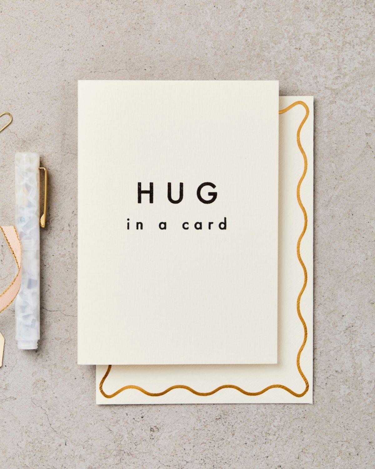 Card with 'HUG in a card' text on a textured surface