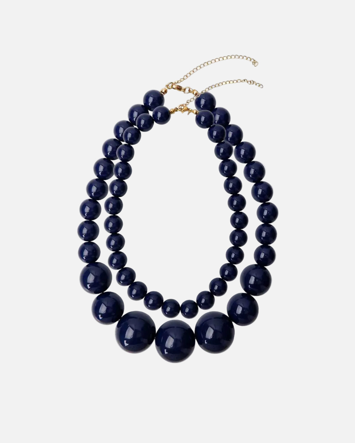 A double-strand statement necklace featuring glossy dark navy blue beads of varying sizes, with a gold-tone chain extender clasp, shown on a plain white background.
