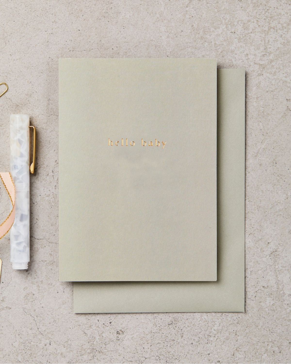 Green notebook with 'Hello World' on a textured surface
