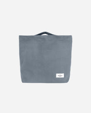 Dusty blue tote bag with a visible brand label 