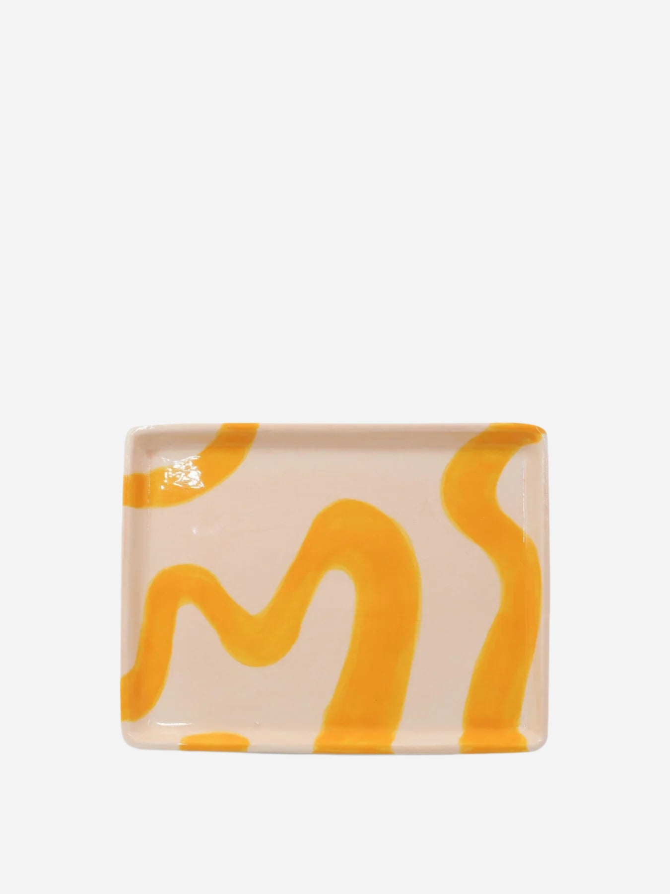 Rectangular ceramic tray with wavy yellow design on a beige background