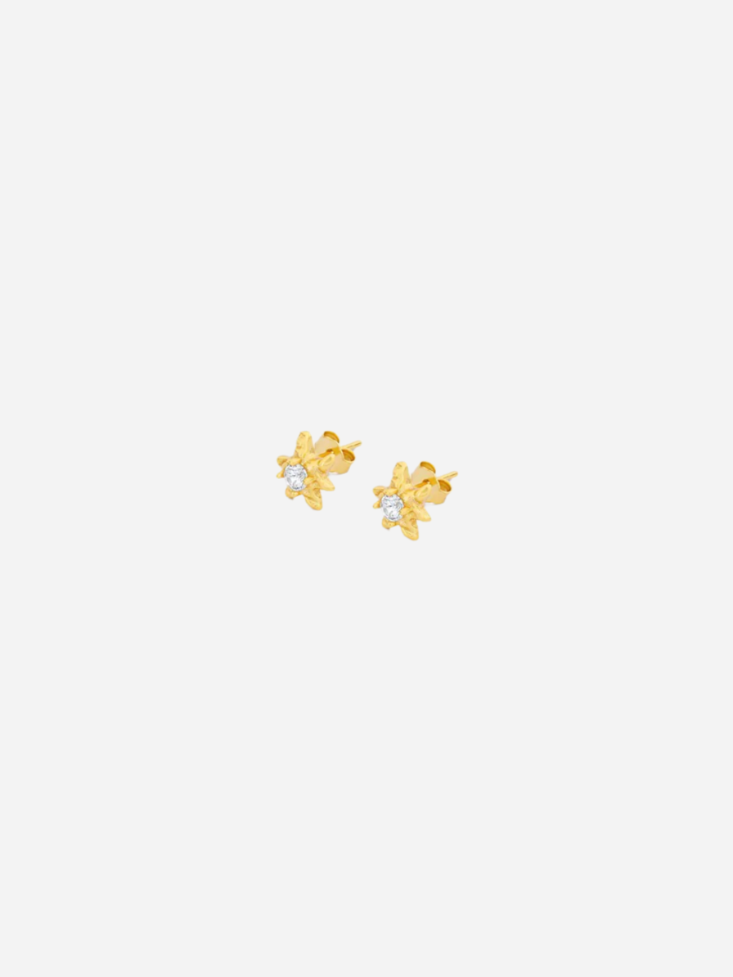 A pair of gold-colored star-shaped stud earrings with a central cubic zirconia