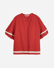 Red blouse with lace trim on a white background