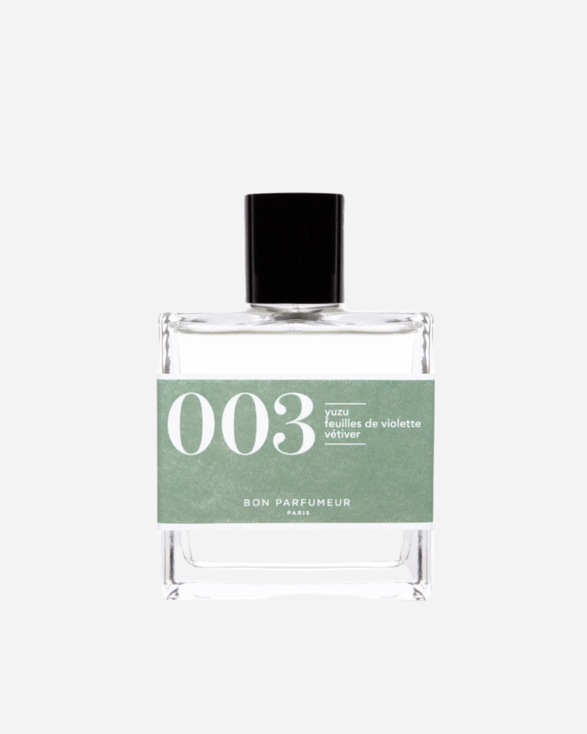Clear square perfume bottle with black lid and green label