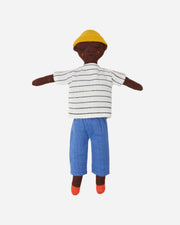 Plush toy of a child wearing a striped shirt, blue pants, and a yellow hat on a white background