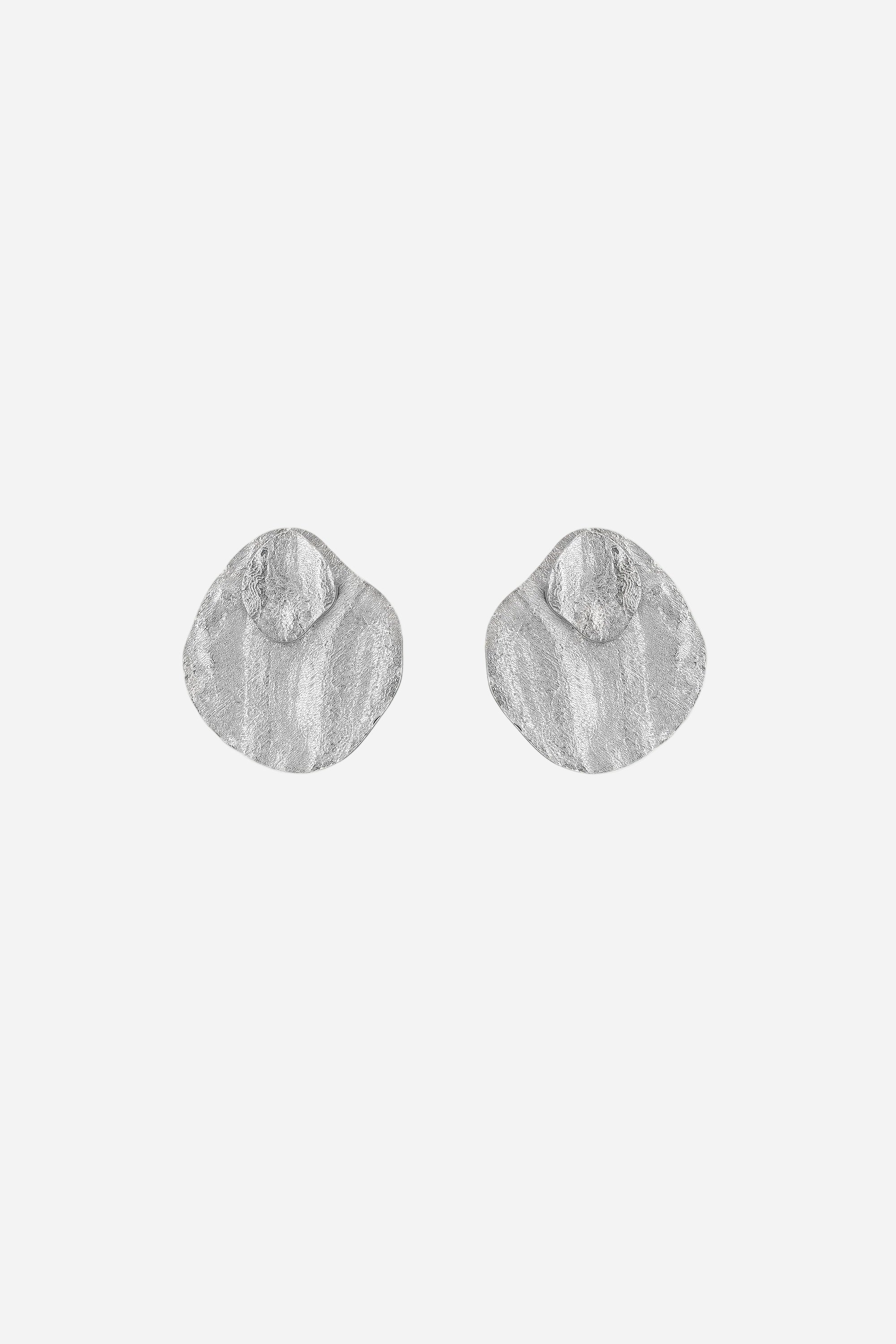 Pair of silver earrings on a light gray background