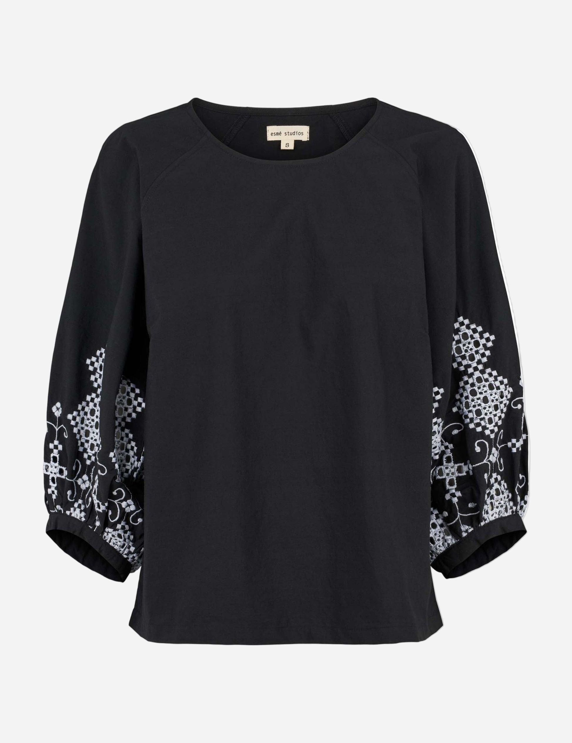 Black blouse with floral patterns on sleeves against a white background