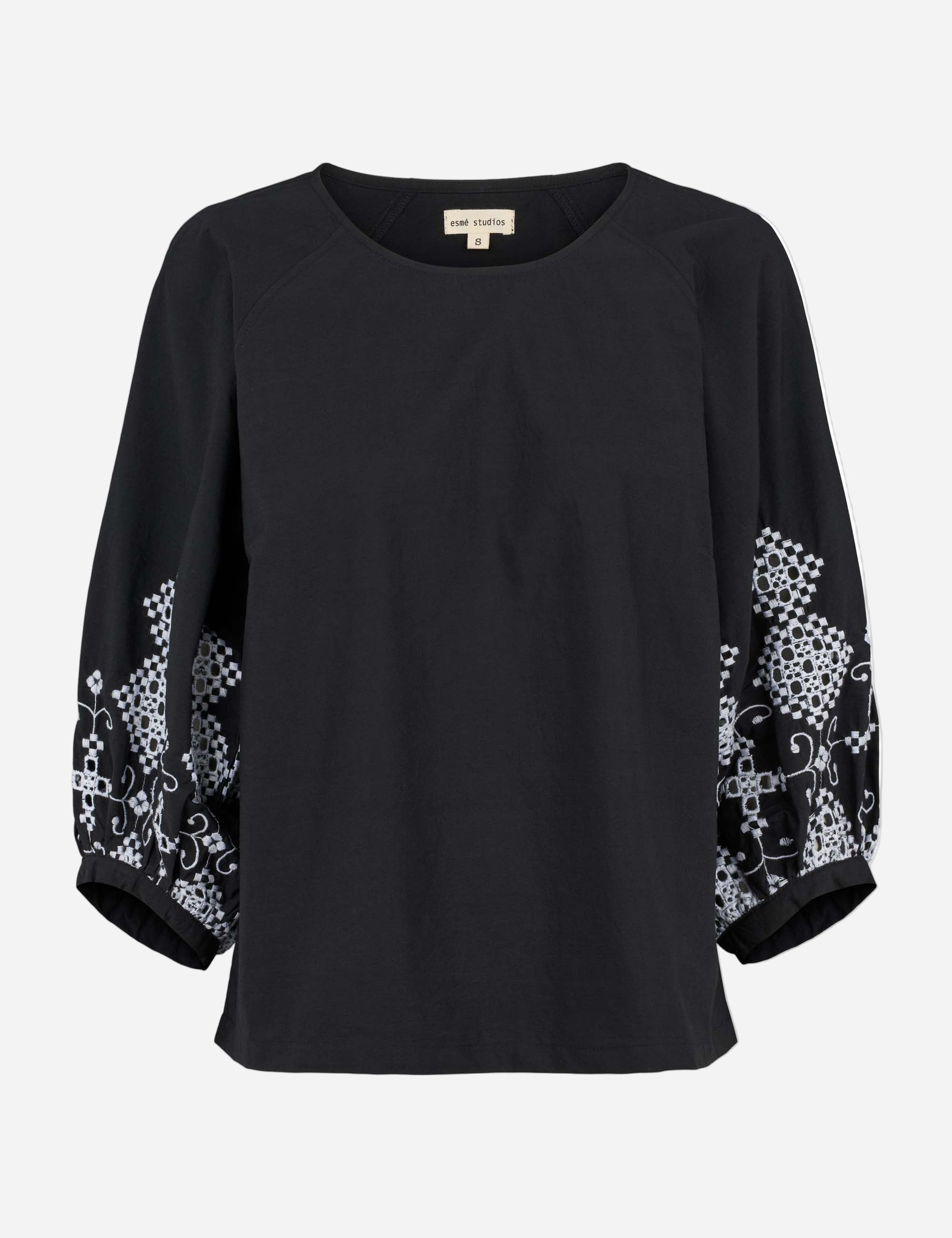 Black blouse with floral patterns on sleeves against a white background