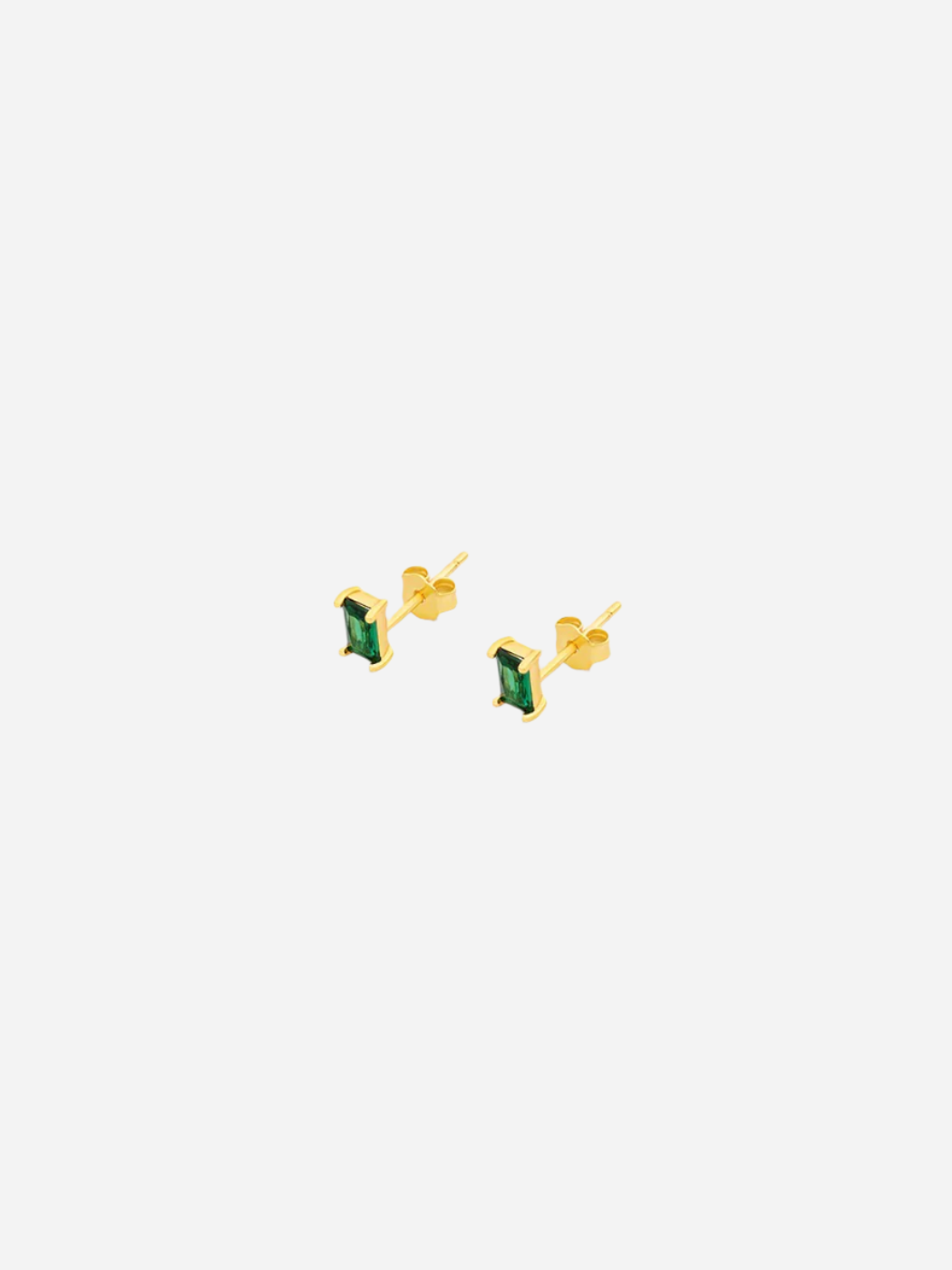A pair of gold-colored stud earrings with baguette cut emerald stones.