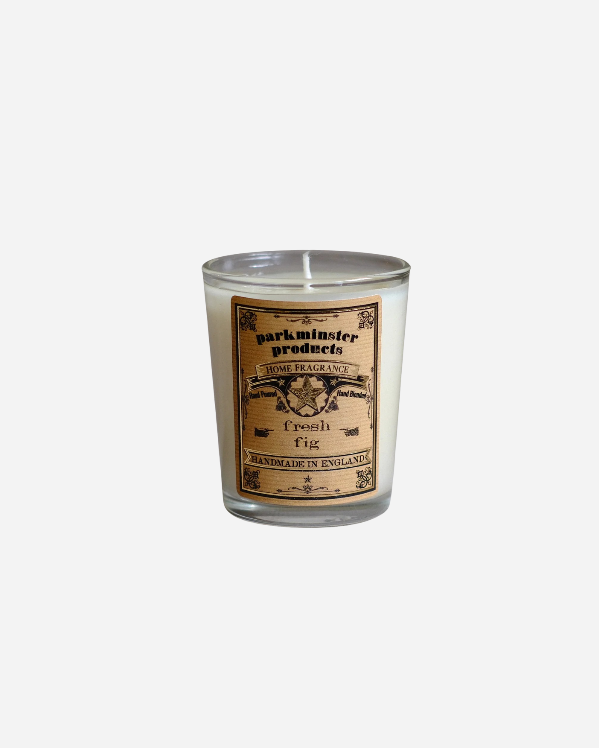 A mini votive candle with a label that reads 'Parkminster', 'Fresh Fig', and other text, set in a clear glass container.