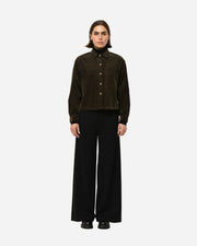 MODEL wearing a dark brown corduroy jacket and black pants on a white background