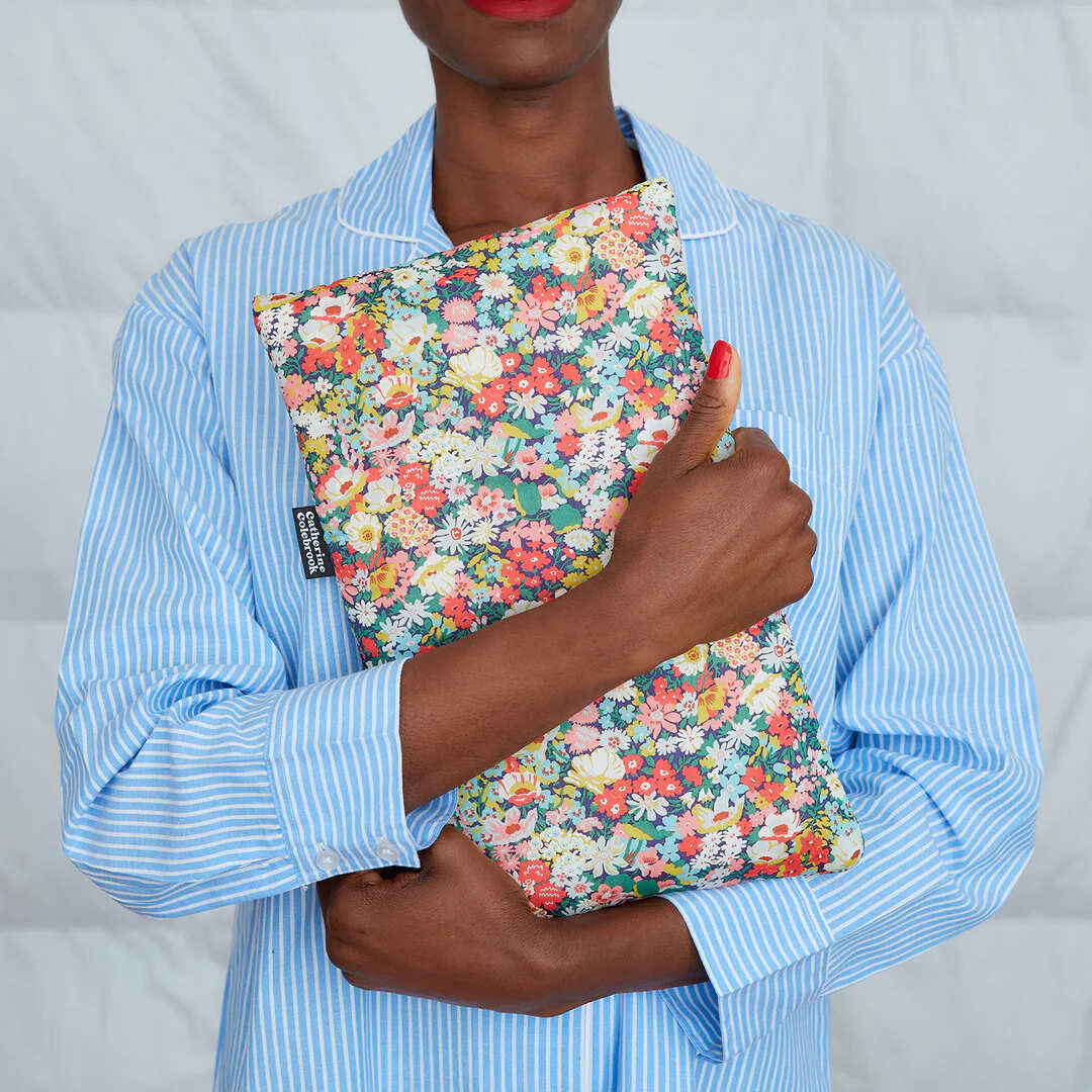 Person holding a floralhot water bottle with a plain background