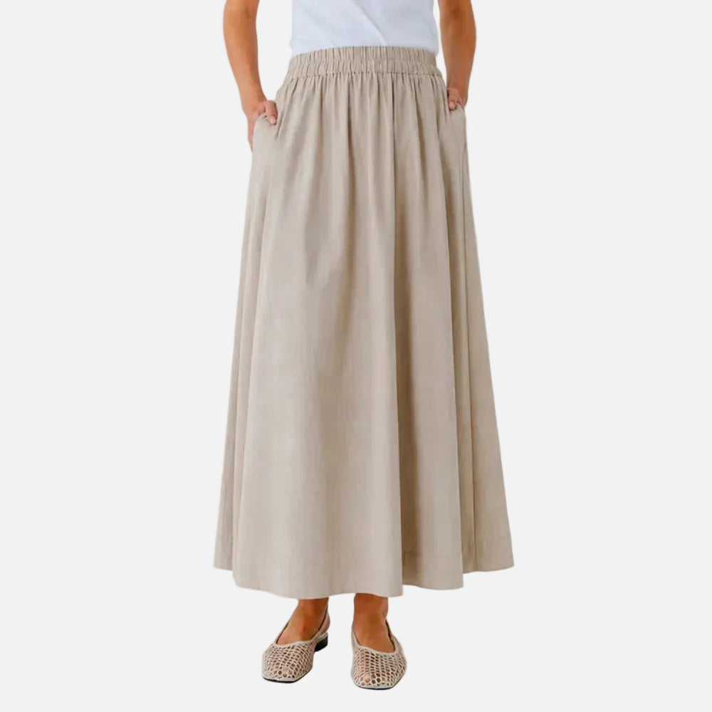 Beige skirt worn by a person on a white background