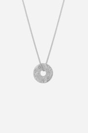Silver necklace with a round pendant on a light gray background
