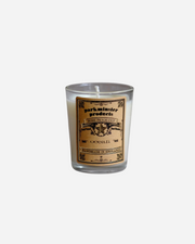A clear glass mini votive candle with a label featuring the brand name Parkminster and product details.