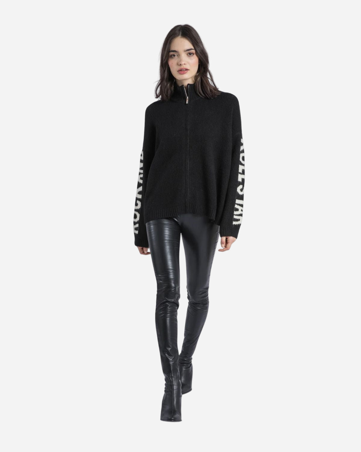 Woman wearing a black zip-up sweatshirt with white text and black leather pants on a white background