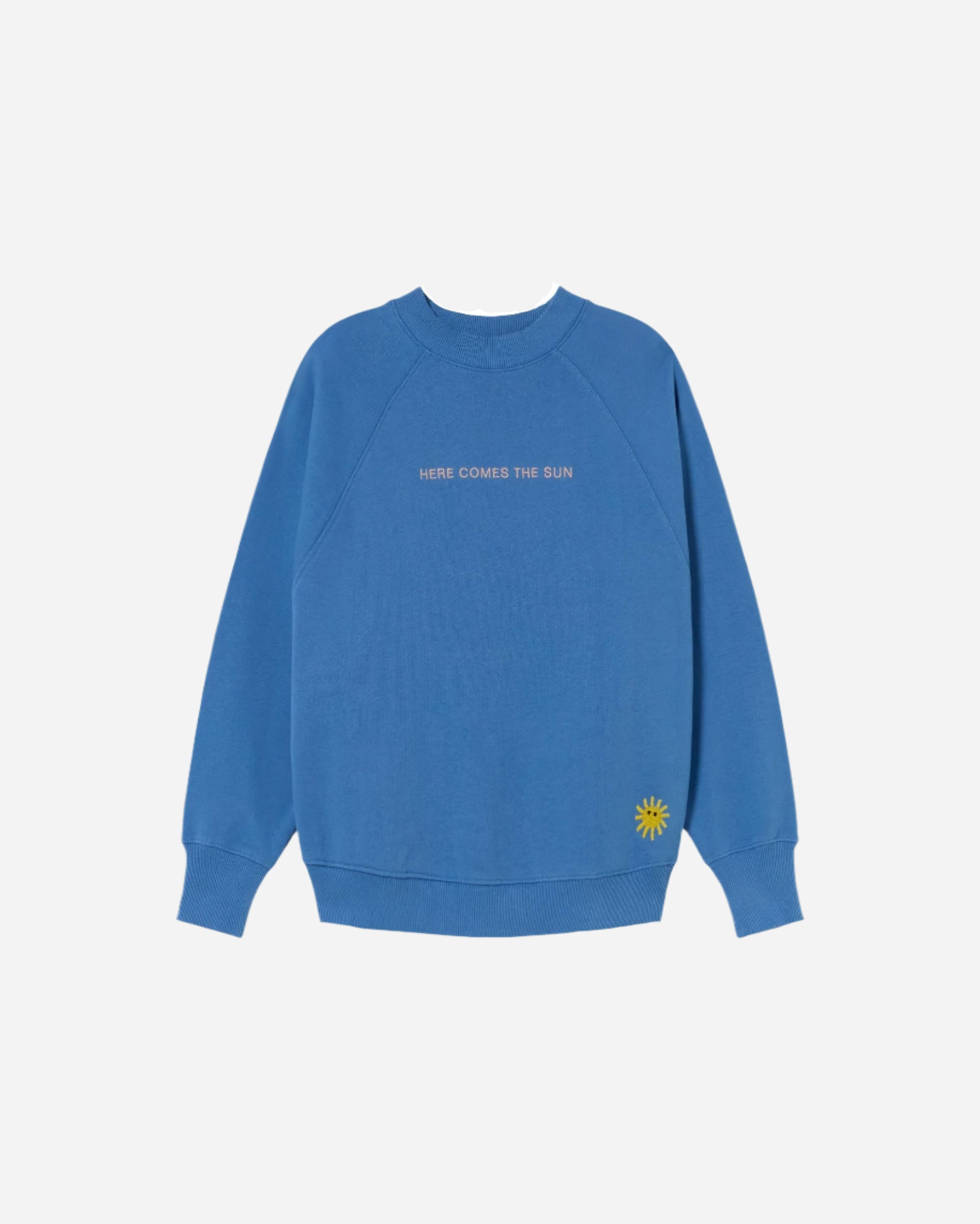 Bright blue round neck sweatshirt with HERE COMES THE SUN embroidered on the front and Sun embroidery on the bottom left side
