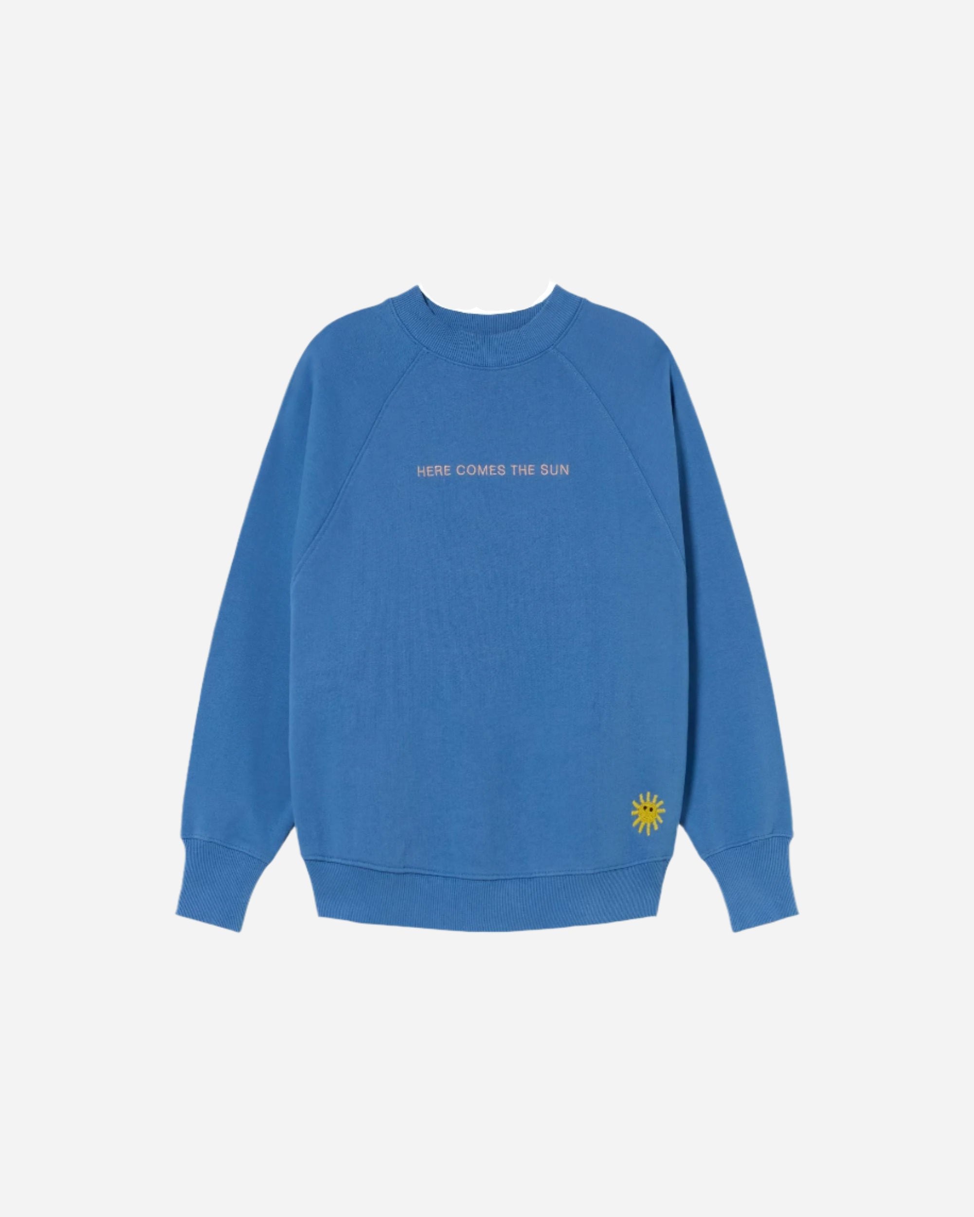 Bright blue round neck sweatshirt with HERE COMES THE SUN embroidered on the front and Sun embroidery on the bottom left side
