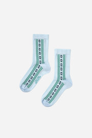 Pair of light blue socks with green patterns on a white background
