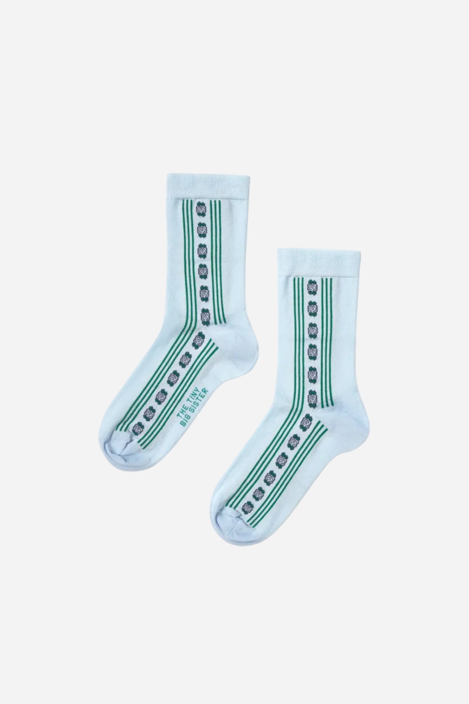 Pair of light blue socks with green patterns on a white background