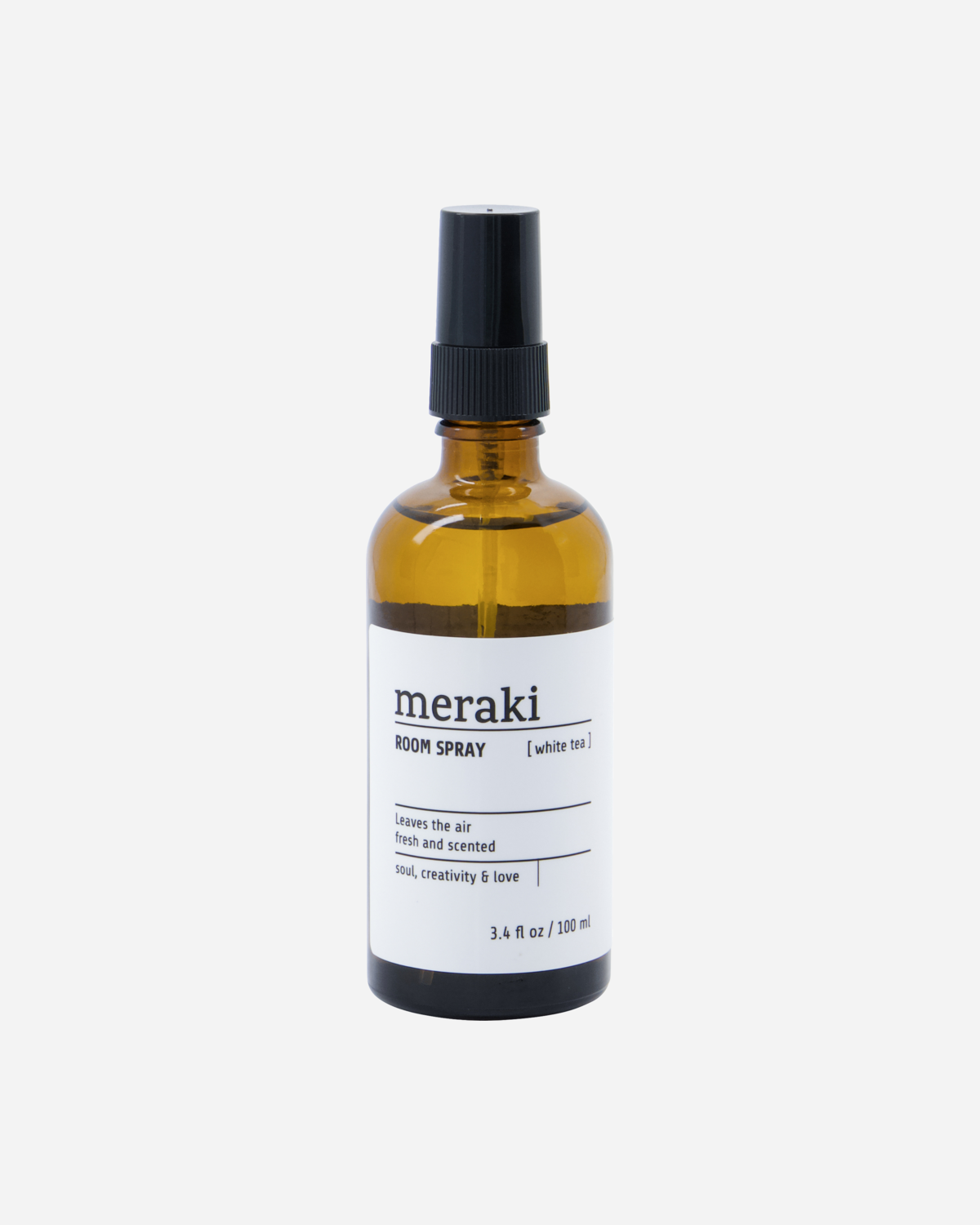 A glass room spray bottle with a black pump, labeled 'meraki', containing the White Tea scent.