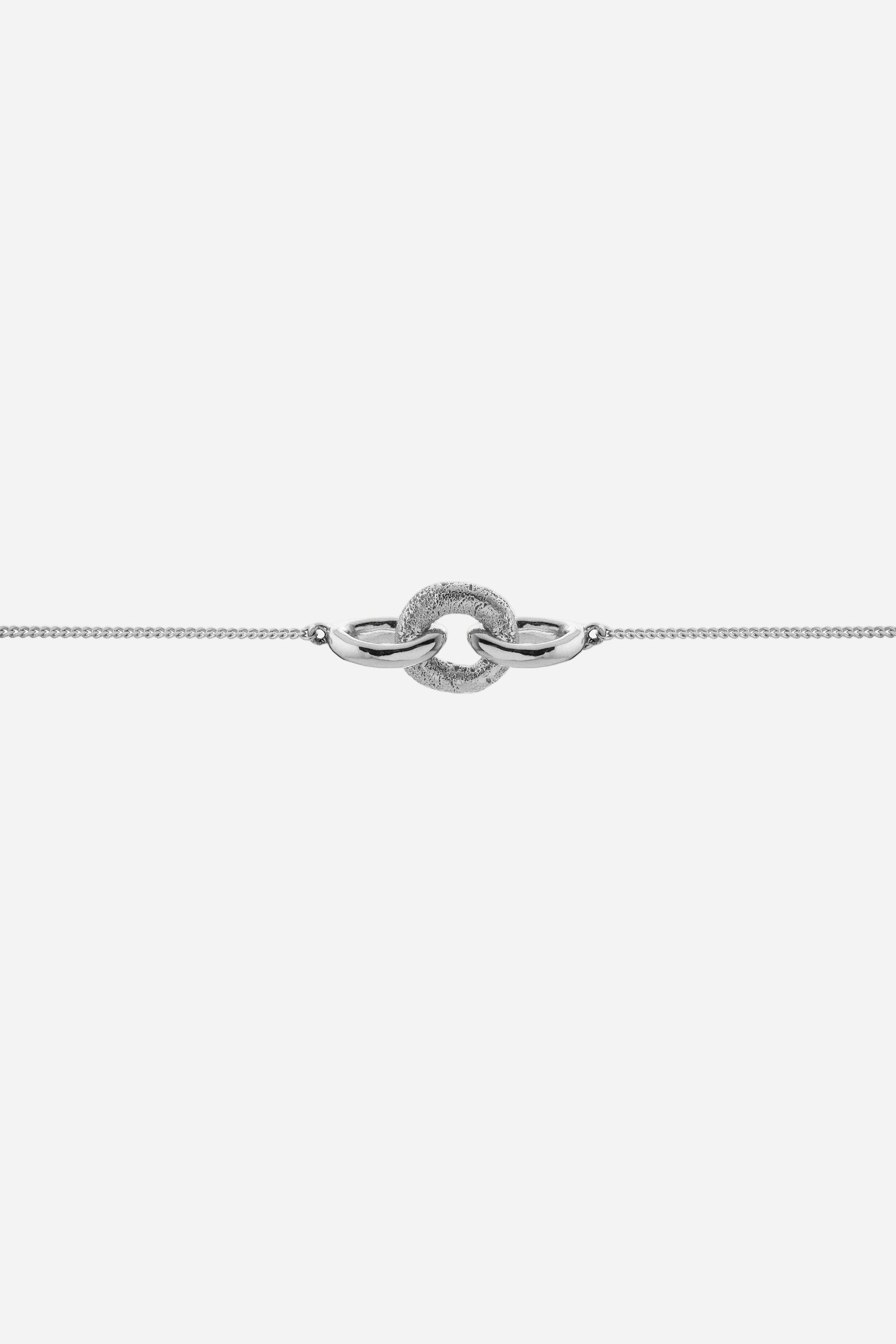 Silver bracelet with a unique clasp design on a light gray background