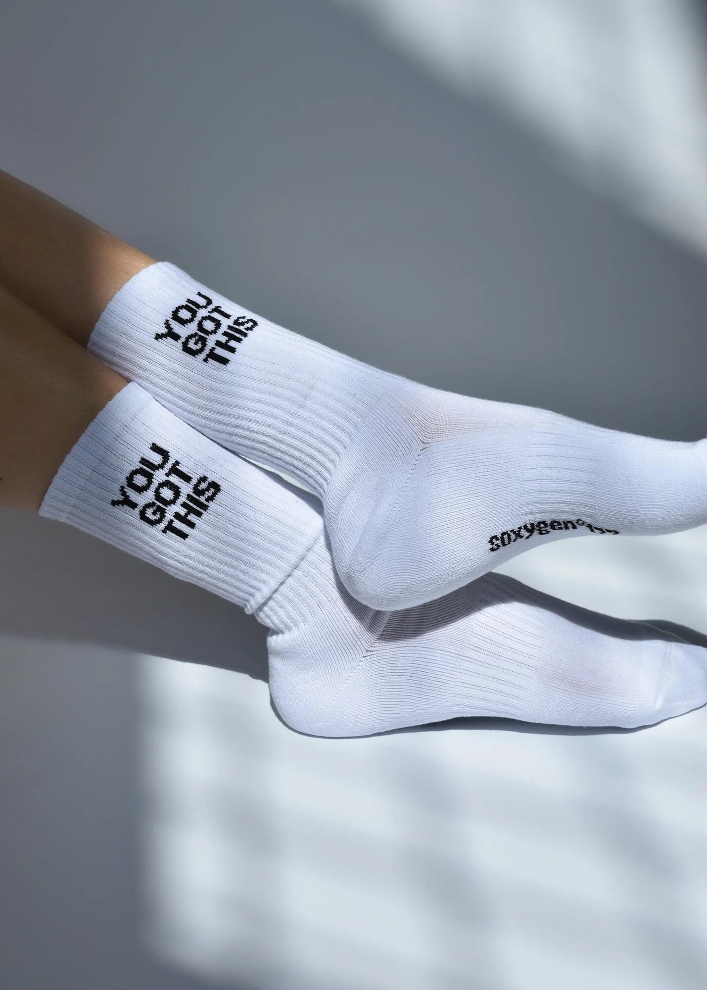 A pair of white crew length socks with the slogan 'YOU GOT THIS' printed on the side, featuring arch support and cushioned heel and toe.