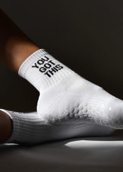 A white grip sock with 'YOU GOT THIS' text on the ankle area, featuring a non-slip sole, arch support, and elasticated stretch.