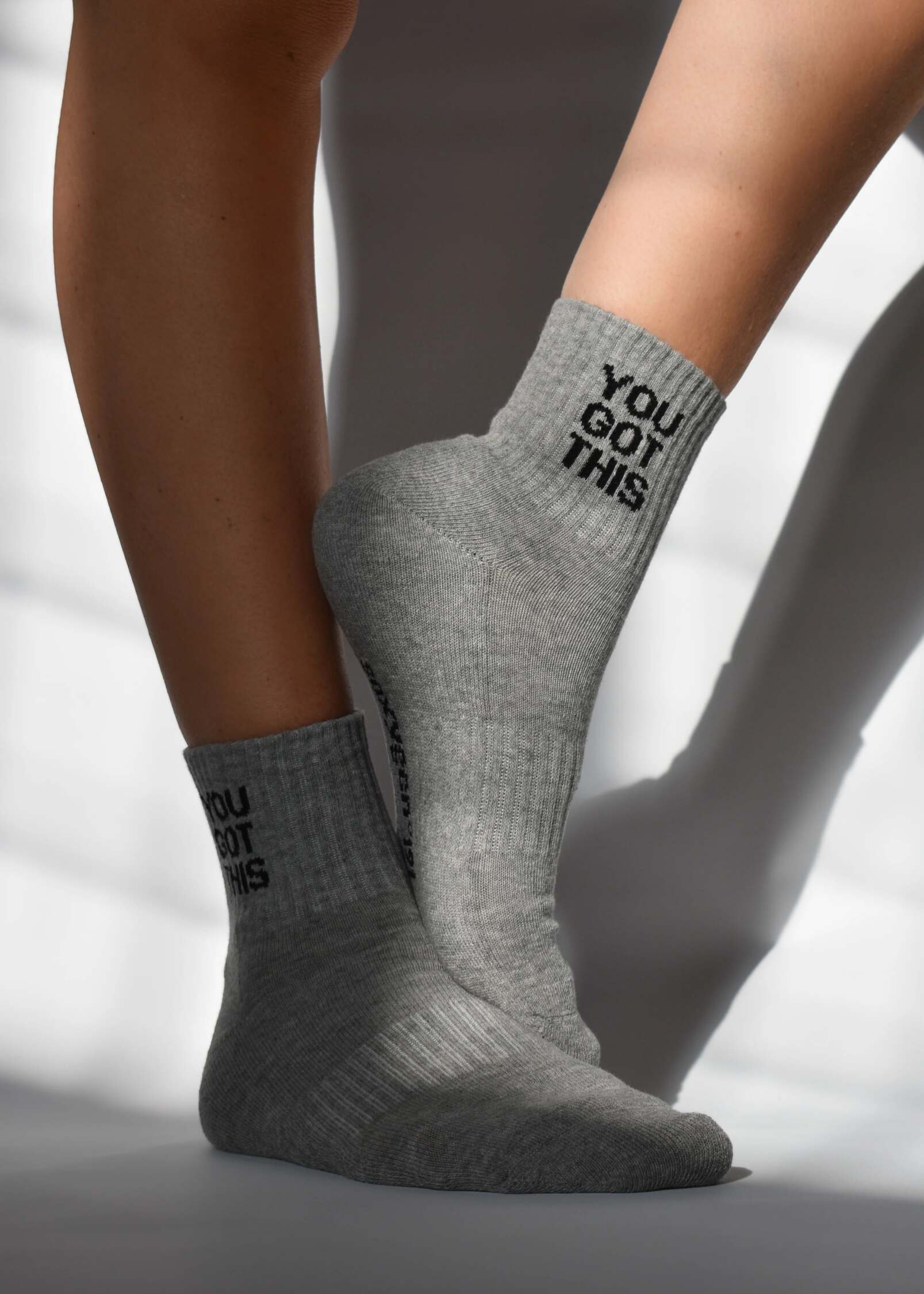 A pair of gray ribbed crew socks with 'YOU GOT THIS' text detail above the ankle, featuring arch support and cushioned heel and toe.