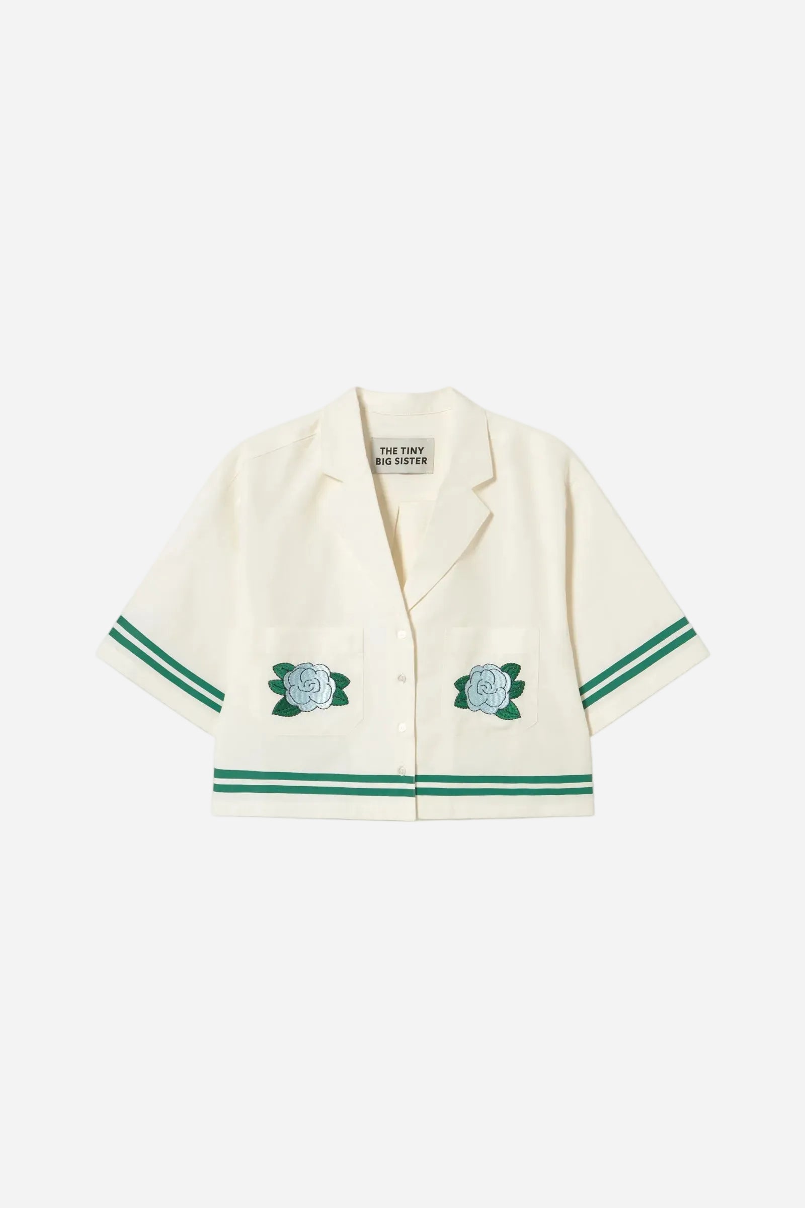 White shirt with green accents and embroidered roses on a white background